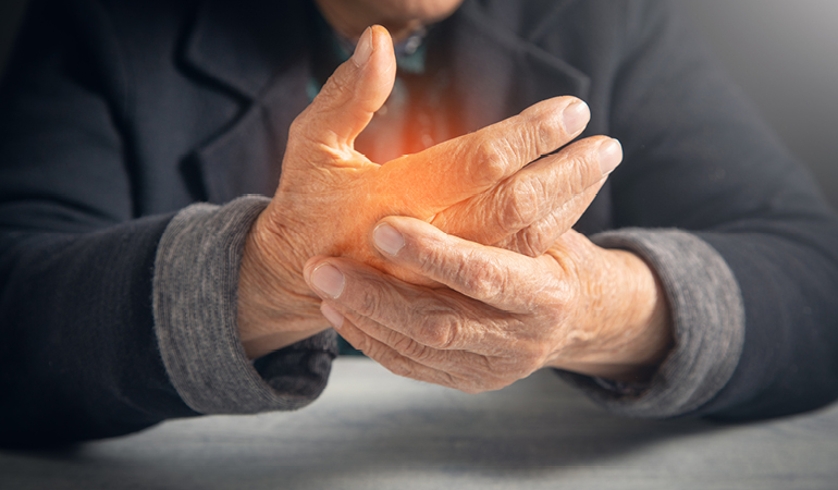 A senior resident with arthritis receiving gentle, non-weight-bearing exercises from a physiotherapist in a dedicated Senior wellness home for arthritis near Delhi.